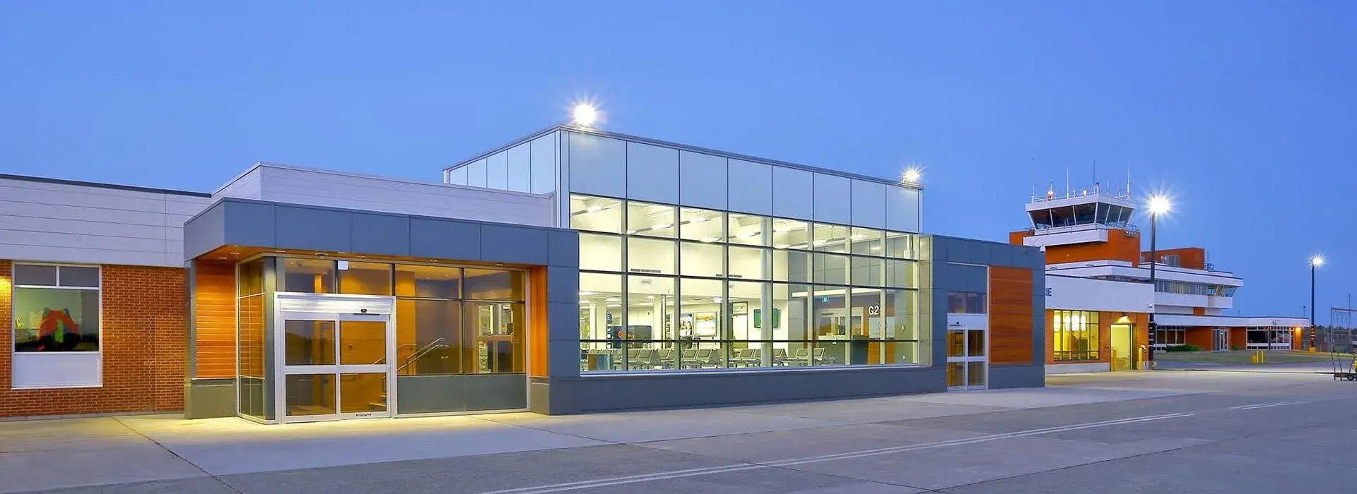 Back of airport terminal showing where large windowed room where passengers would wait to board
