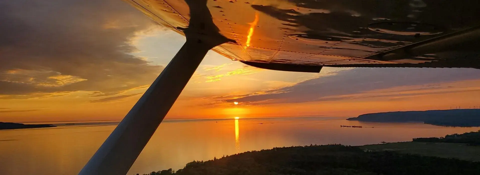 Sunset over water inside small plane